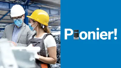 Eine Lagerhalle mit vielen Paletten. Ein Mann und eine Frau unterhalten sich. Beide tragen einen blauen Mundschutz und einen Helm. Der Mann trägt Hemd und Sakko, die Frau ein weißes T-Shirt und eine Latzhose.